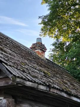 Detailed view of an old brick pipe and damaged slate roof, building renovation Stock Photos