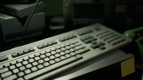 Detailed view of an old computer keyboard in an office setting at night Stock Footage 293238900