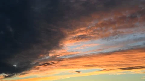 Detailed view of orange and grey sunset clouds moving across the sky.  Stock Footage 135350564