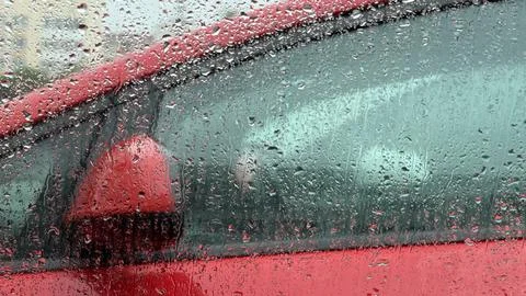 Detailed view of rain running down a glass window, creating a textured overlay Stock Photos