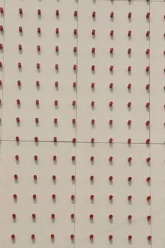 Detailed view reveals a regular pattern of small red cylinders affixed to a c 写真素材