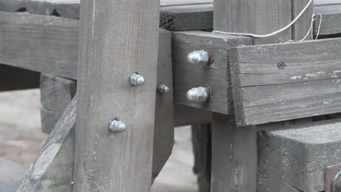 This is a detailed view of a rustic wooden structure, featuring sturdy metal 動画素材 280996924