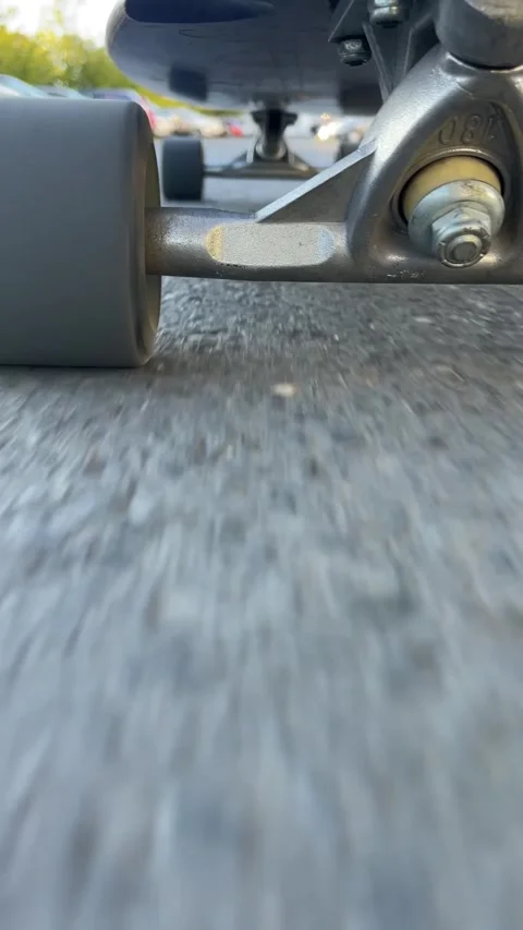Detailed view of skateboard components on gritty road surface 库存影片 336434737