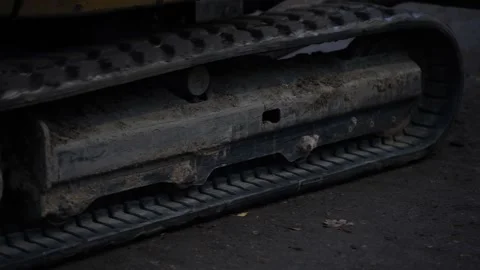 Detailed view of tracked undercarriage on compact excavator covered with dirt Stock Footage 320804028