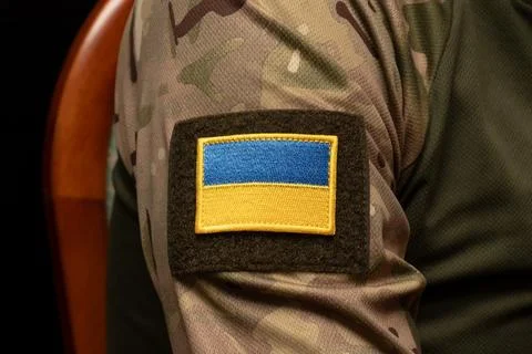 Detailed view of Ukrainian flag patch on military camouflage uniform. Фото