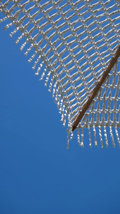 Detailed view of a white woven sun umbrella with hanging tassels Video stock 337319688