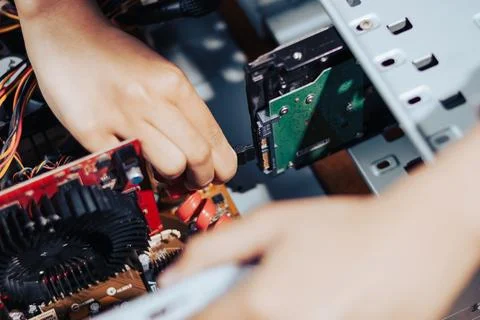 Detailed view of a womans hand assembling computer hardware components and .. Stock Photos