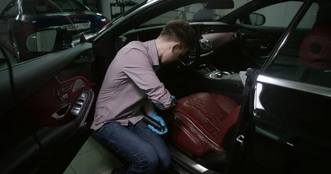 Detailing and cleaning of interior front seats at luxury modern cars. Car care Stock Footage 94900316