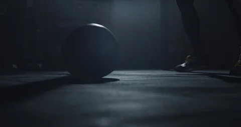 Details of a athletic guy using a cross fit ball to do his hard training workout Stock Footage 125479897