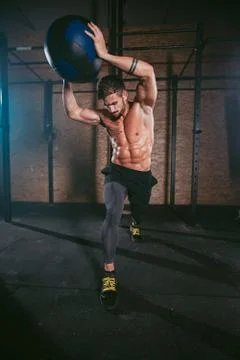 Details of a athletic guy using a cross fit ball to do his hard training workout Stock Photos