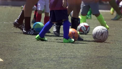 Details of a ball and players at a youth soccer football camp on a turf field. Stock Footage