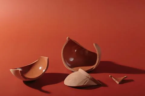 Details of broken ceramic cup on red background Stock Photos