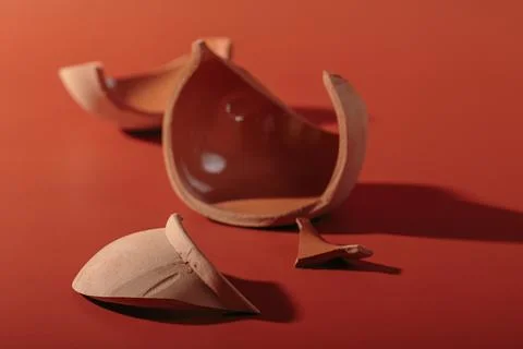 Details of broken ceramic cup on red background Stock Photos
