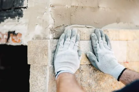 Details of construction worker hands using mortar and stone for paving walls Stock Photos