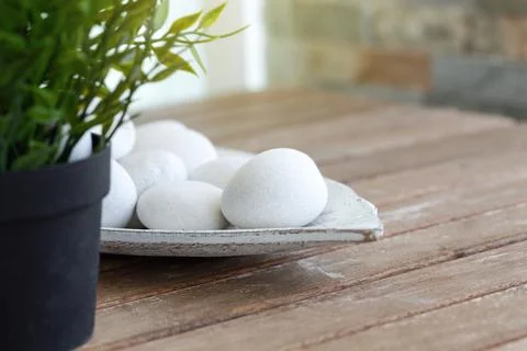 Details of decoration objects in interior. White round stones in vase on wood Stock Photos
