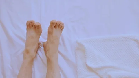Details guy legs on bed Stock Footage 123948599