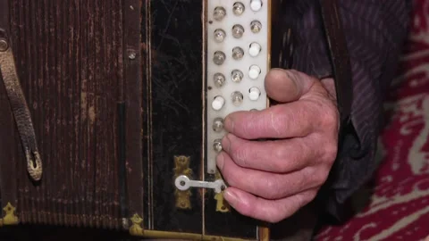Details of a hand on an old accordion while playing Stock Footage 110826664
