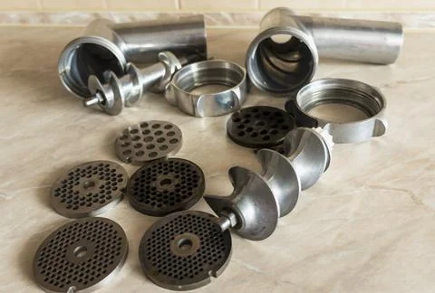 Details of a meat grinder, elements of a kitchen device, disassembled meat .. Stock Photos