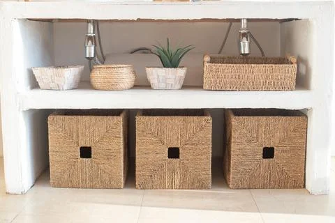 Details of modern cozy white interior with wicker boxes Stock Photos