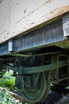 Details of an old rusty steam train weathered parts and a spider web near the Stock Photos