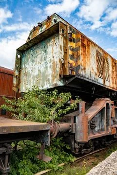 Details of an old rusty steam train surrounded by greenery in a neglected Stock Photos