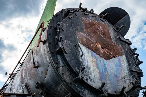 Details of an old rusty steam train under a cloudy sky Stock Photos
