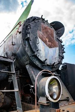 Details of an old rusty steam train in a railway yard under a cloudy sky Stock Photos