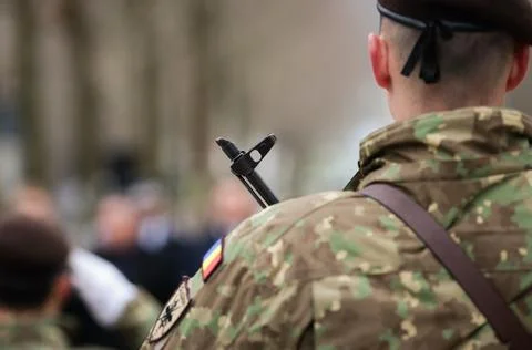 Details with the patch, uniform and weapon of a Romanian soldier during a p.. Stock Photos