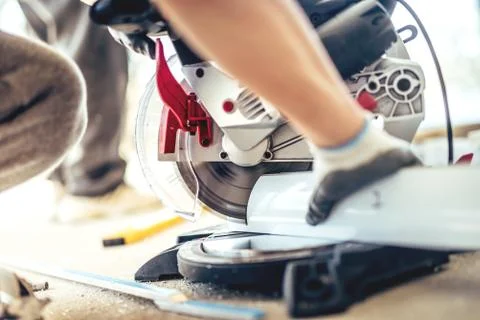 Details of professional worker using a mitre-saw and angle grinder Stock Photos