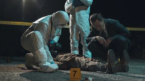 Detective and forensic scientists working hard at crime scene near headless.. Stock Photos
