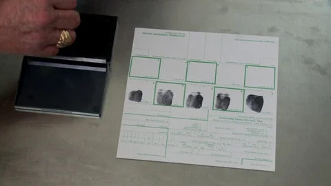 Detective conducting fingerprinting of female suspect, interior police precinct. Stock Footage
