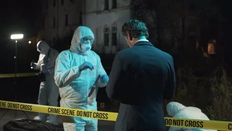 Detective examining main clue brought in by forensic scientist at crime scene Stock Footage 283866216