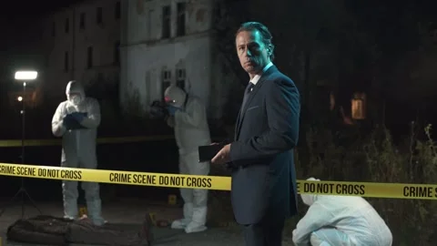 Detective inspecting area and taking notes in notebook at crime scene at night  Video stock 283866386