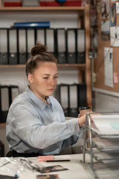 Detective working at desk in her office, processing evidence Stock Photos