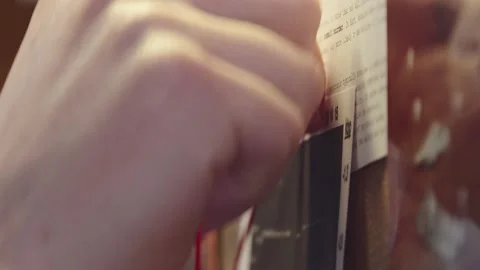 Detective's hand on the investigative board pulls a string on pins that Video stock 237457182
