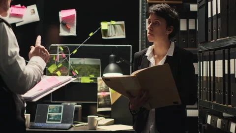 Detectives team reviews documents Stock Footage 242540604