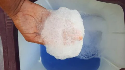 Detergent foam on hands while washing cloths Stock Photos