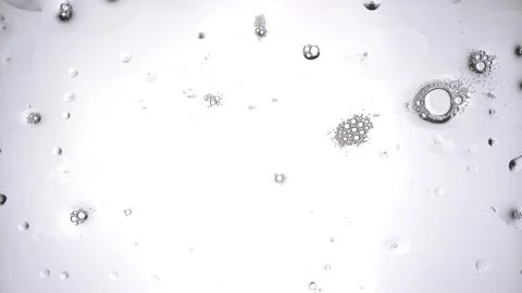 Detergent splashes on the glass against a bright white background. The bubbles Stock Footage 136640974