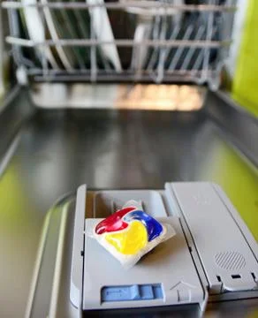 Detergent tablet on dishwasher tray. 库存照片