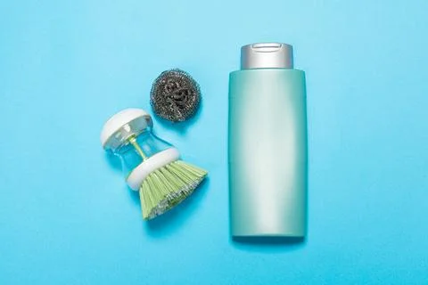 Detergent for various surfaces and rag sponge Light pastel blue background. P Stock Photos