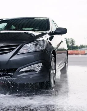Detergent is washed off the front of a gray car with water Stock Photos