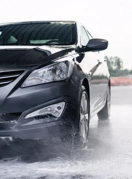 Detergent is washed off the front of a gray car with water Stock Photos