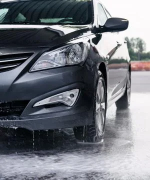 Detergent is washed off the front of a gray car with water Stock Photos