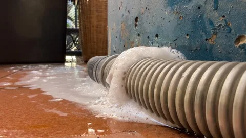Detergent water and foam bubble leaking from plastic drain pipe on ground. Stock Footage 310286954
