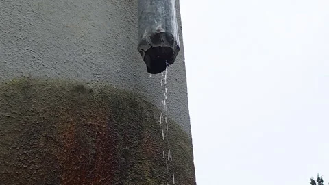 Deteriorated downspout spilling steady droplets onto surface. Industrial style  Vídeos de archivo 330267610