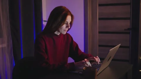 A Determined and Focused red-haired programmer Woman is Working Late into the Stock Footage 297565088