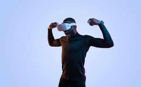 Determined black guy in VR goggles shouting while playing video game Stock Photos