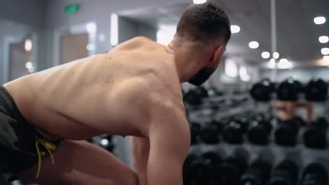 The determined bodybuilder trains his biceps in the gym, approved frame, man Stock Footage 156471636