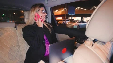 A determined businesswoman multitasks while driving, making a call and using her Stock Footage 298288714