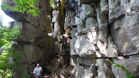 Determined climbers scaling a rugged rock face at Rattlesnake Point 動画素材 345554679